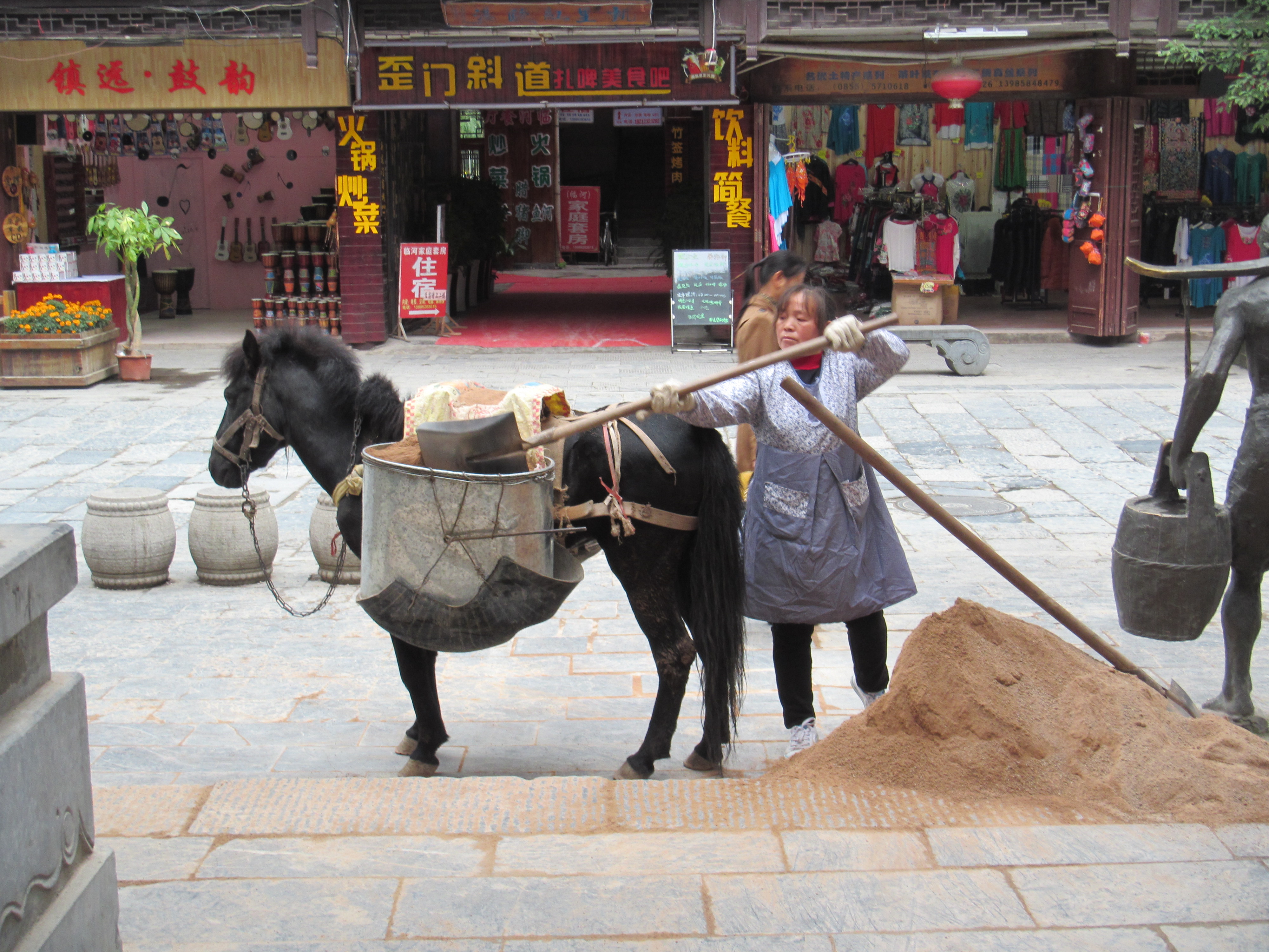 A woman loading up her horse with gravel 